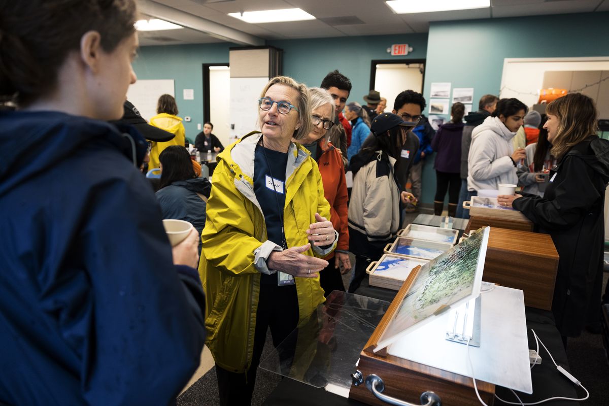 People indoors looking at a map and talking