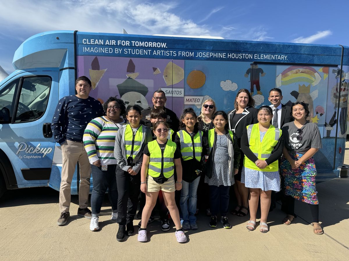 Houston Elementary School Artists pose with Superintendent Segura by their art on CapMetro bus