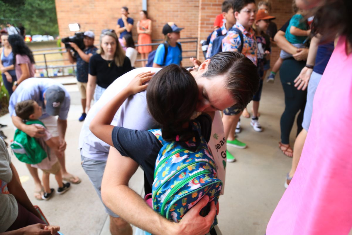 Father hugging child first day of school