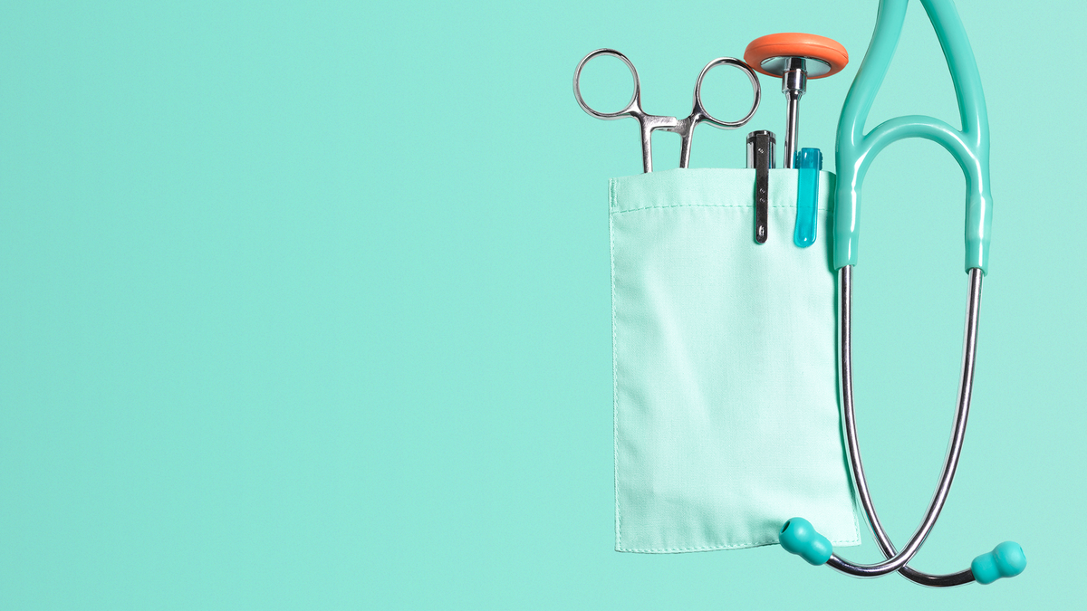 A doctor's tools, including a pair of scissors, pens, and a stethoscope.
