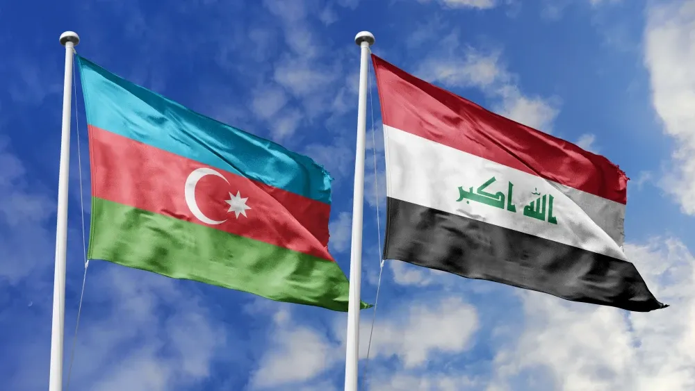 The flags of Azerbaijan and Iraq flutter in the breeze on a cloudy day. Shutterstock