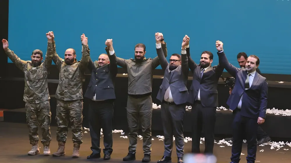 Syrian President Ahmed al-Sharaa appears in military uniform during a ceremony marking the first anniversary of the fall of the Assad regime, on December 8, 2025.  Shutterstock