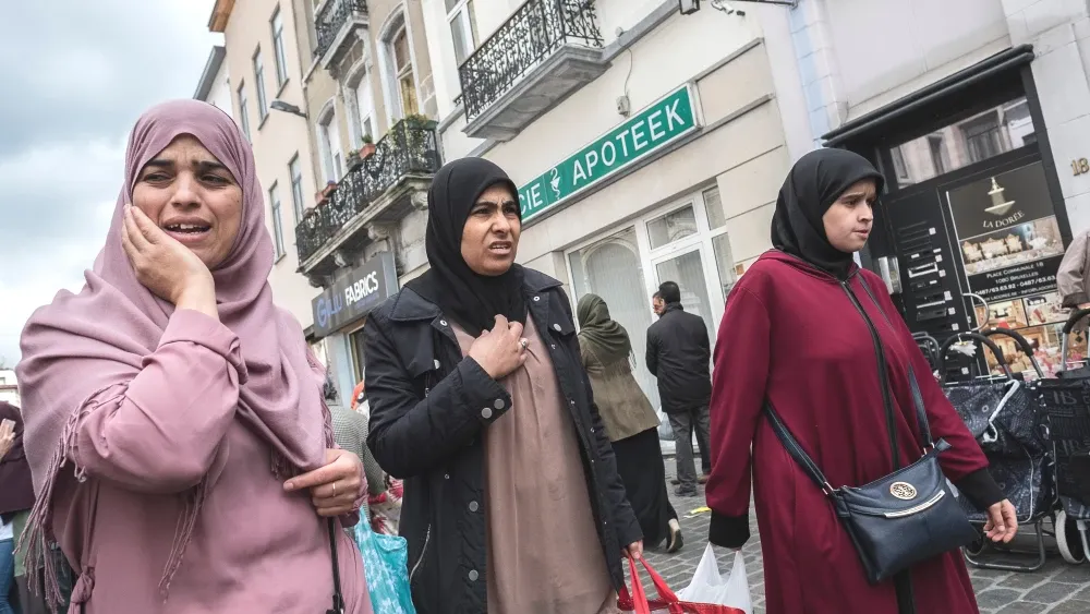 Three Muslim women go shopping in Molenbeek Market, Brussels, Belgium. Molenbeek has become infamous for Islamic terrorism; Oct. 5, 2018.  Shutterstock
