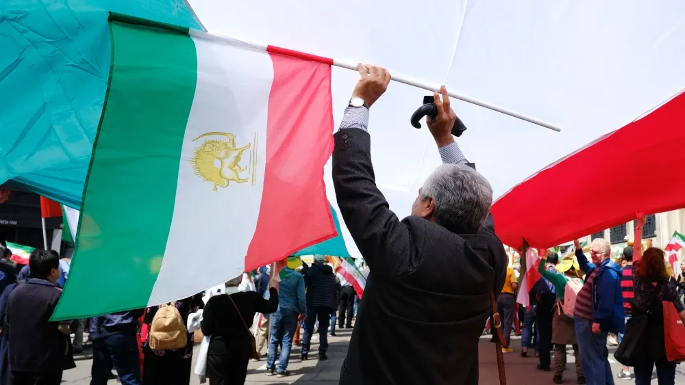 Protesters hold Iranian flags at a demonstration in Belgium against the Islamic Republic. Shutterstock
