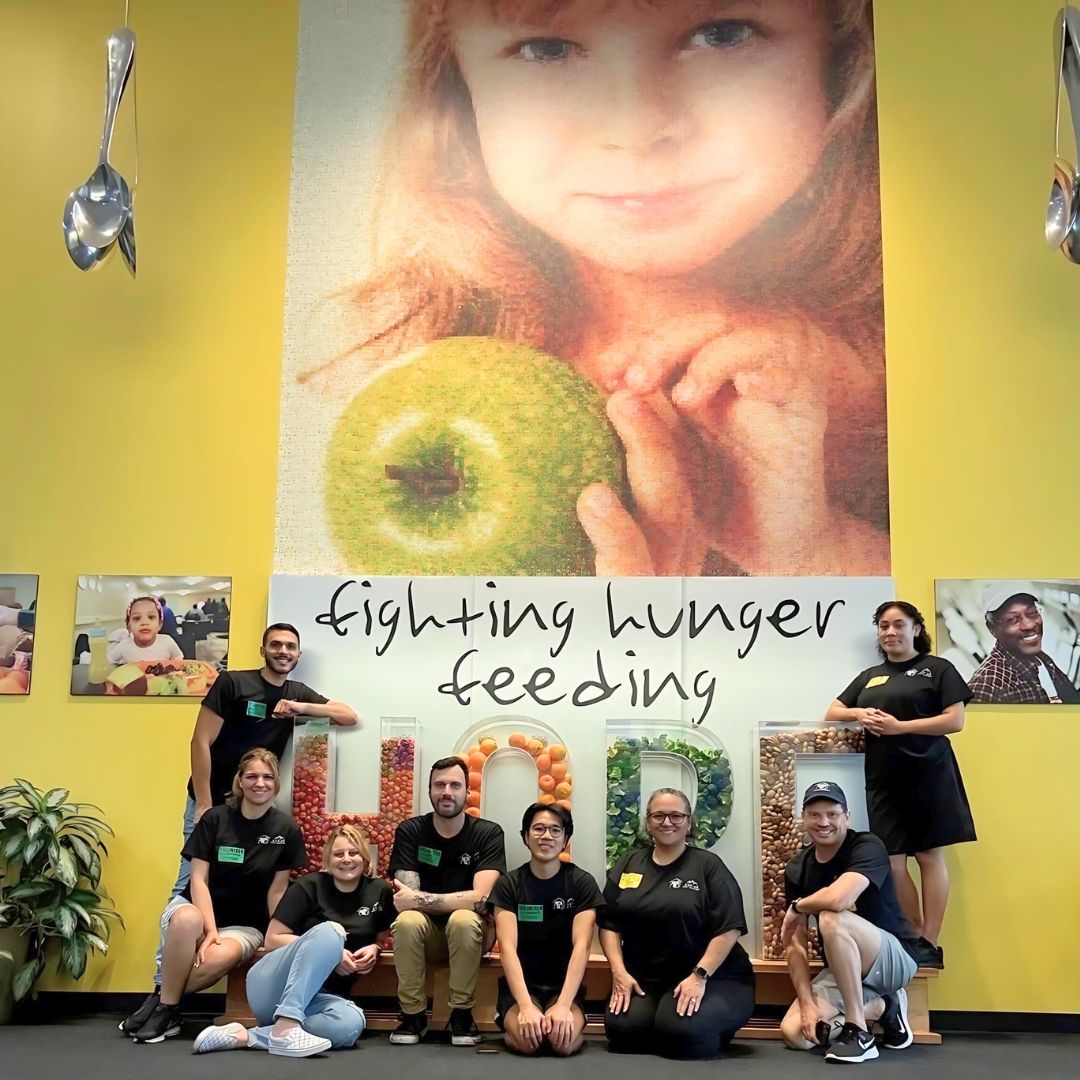 Aspire Legal crew under "Fighting Hunger Feeding Hope" sign