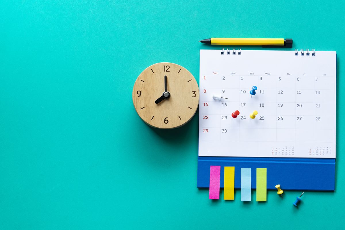 Close up of calendar and clock on a green background