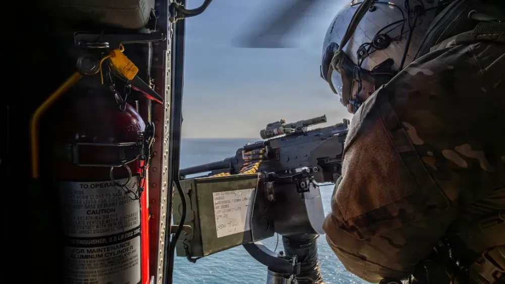 A U.S. Navy Sailor conducts flight operations in an MH-60S Sea Hawk helicopter, attached to Helicopter Sea Combat Squadron (HSC) 14, above Nimitz-class aircraft carrier USS Abraham Lincoln (CVN 72) in...