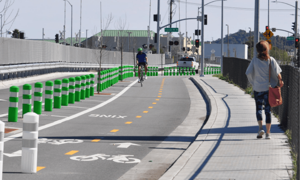 Bike lane and sidewalk with individuals riding and walking.