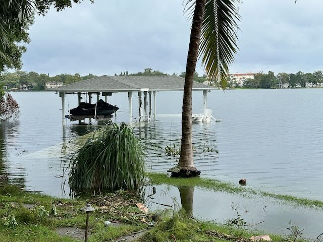 Boat dock with a jet ski hanging in it as flood waters from a lake swamp over the floor