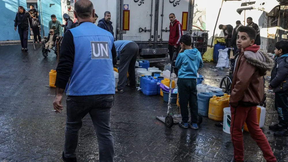 Palestinians fill pots with potable water from the United Nations Relief and Works Agency for Palestine Refugees in the Gaza Strip.  Shutterstock