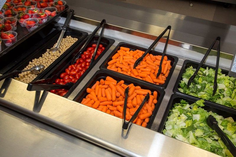 Salad Bar with lettuce, carrots and tomatoes and strawberries
