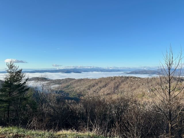 Vista of mountains with clouds and fog lying in the valleys