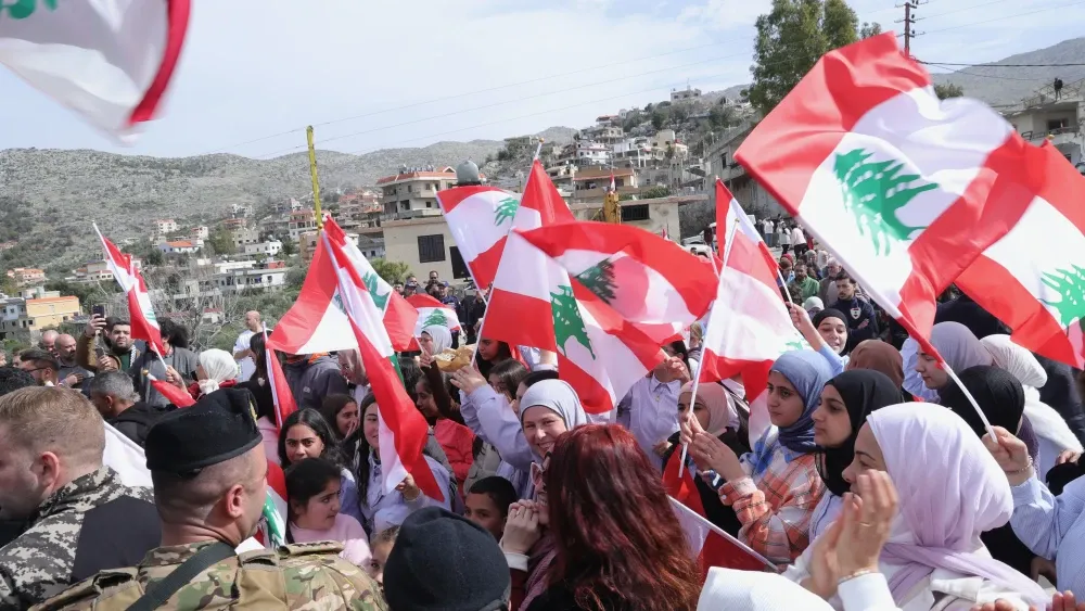 Young men and women from the town of Kfarshouba raising Lebanese flags in the town square to welcome Lebanese Prime Minister Nawaf Salam, February 8, 2026.  Shutterstock