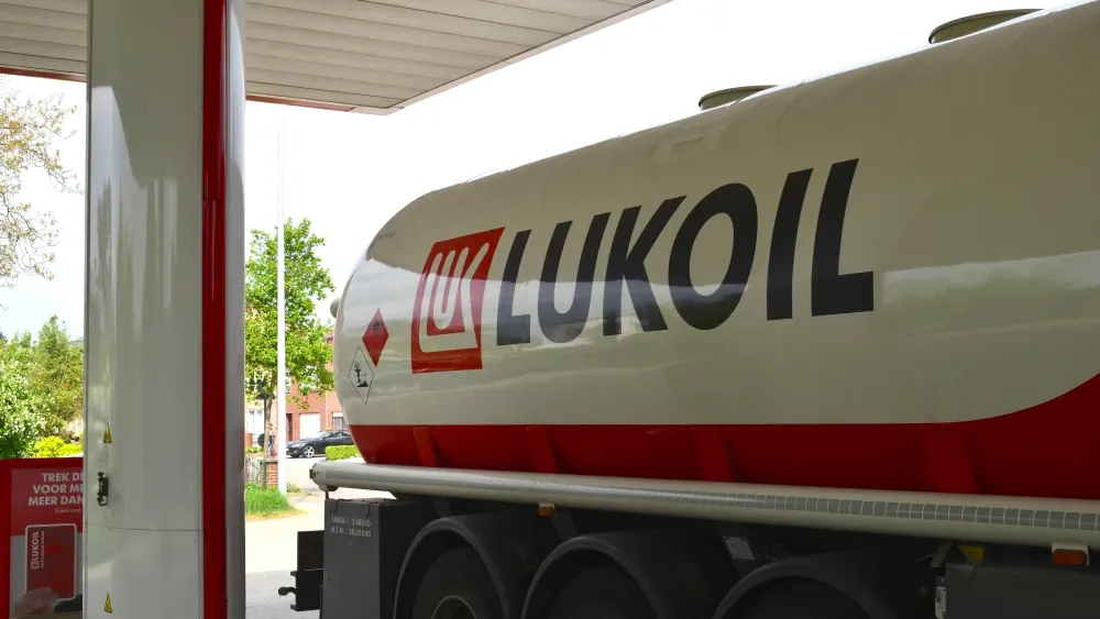 A Lukoil supply truck fills tanks in a petrol station.  Shutterstock
