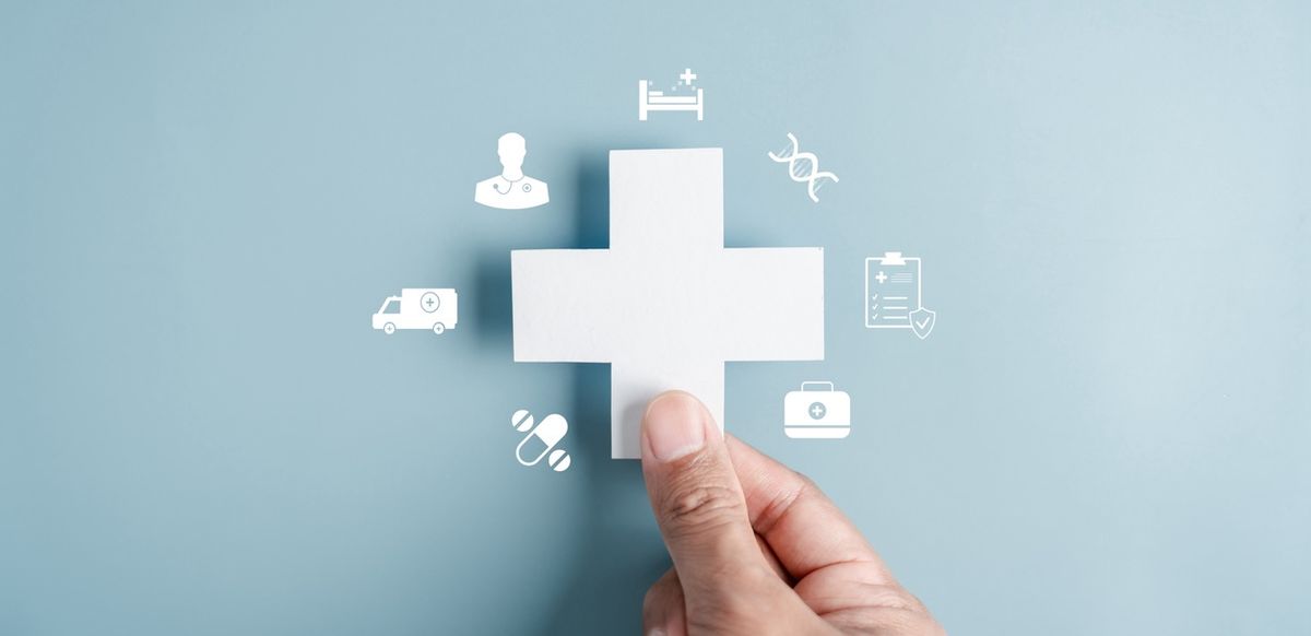 Health cross with symbols and hand