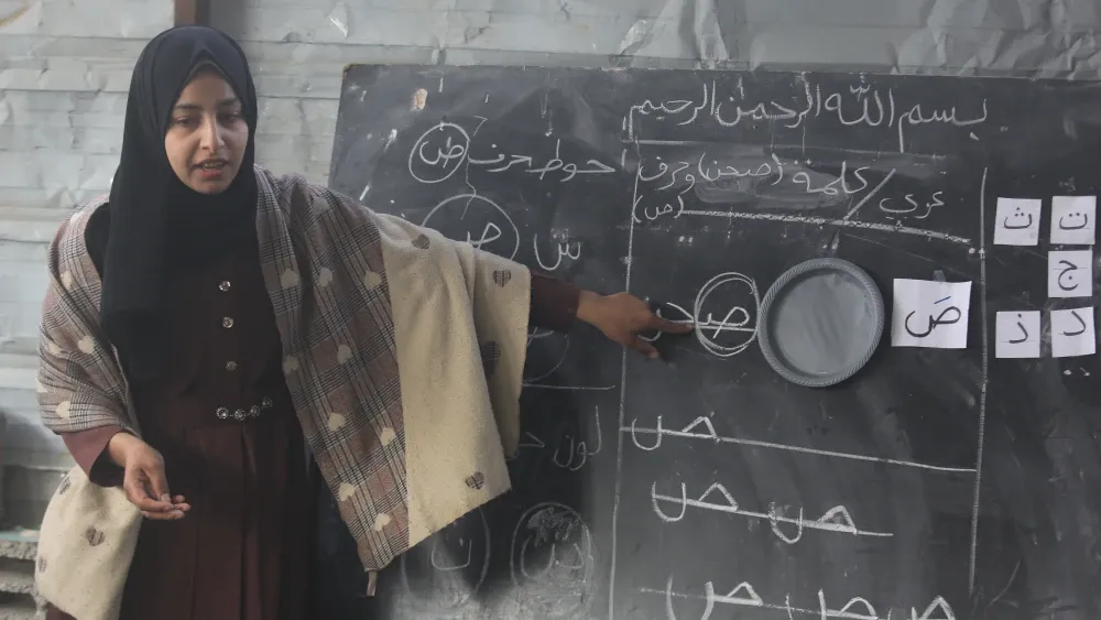 A teacher instructs Palestinian students in a makeshift school building in the Gaza Strip in January 2026.  Shutterstock