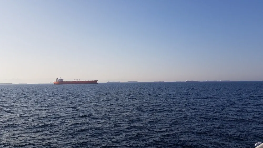 Cargo ships line the horizon in the Strait of Hormuz.  Shutterstock