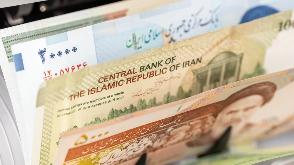 A machine counts Iranian rial banknotes.  Shutterstock