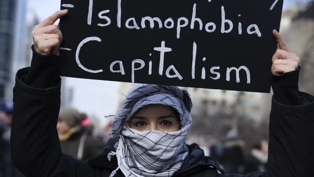 A protester holds a sign denouncing white supremacy, capitalism and 