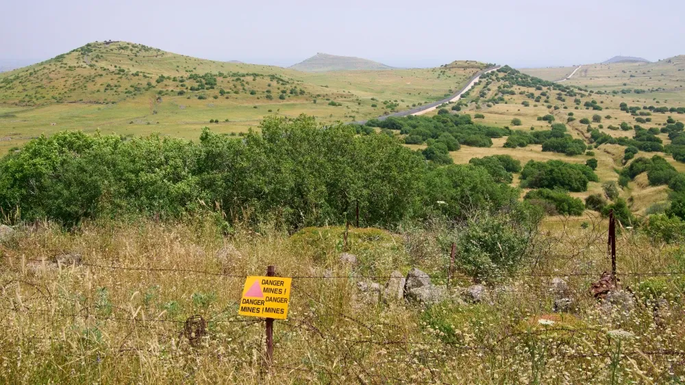 The restricted military zone along border between Israel and Syria in Golan Heights. A sign warns “Danger mines.” Shutterstock