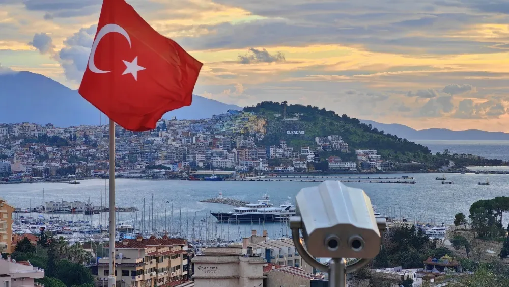 The Turkish flag waves over the harbor of Kusadasi, on Turkey's western Aegean coast, at sunset.  Shutterstock