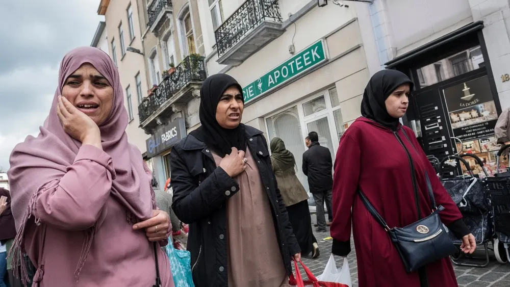 Three Muslim women go shopping in Molenbeek Market, Brussels, Belgium, on Oct. 5, 2018. Molenbeek has become infamous as a center of Islamic terrorism. Shutterstock