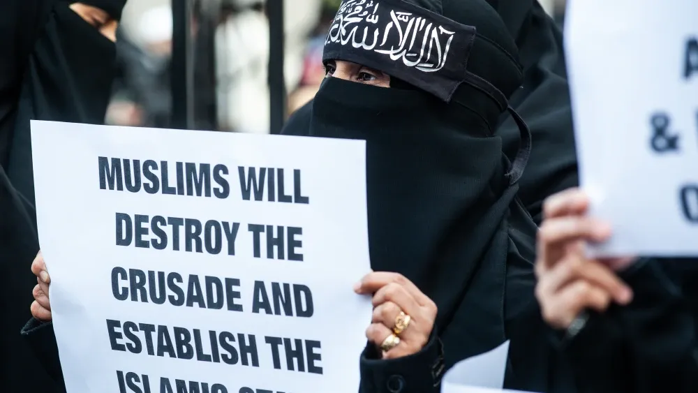 Muslim woman with Islamist sign