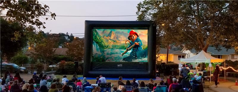 Paddington in Peru on a movie screen in a park