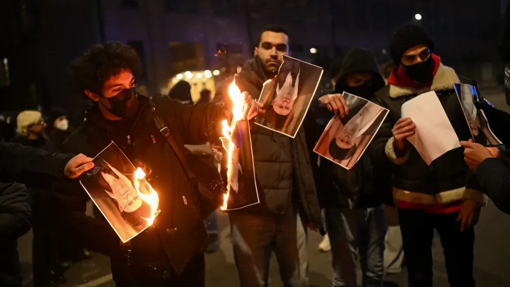 People burn photos of Iran's Supreme Leader Ali Khamenei on January 10, 2026, in Milan, Italy, in support of Iranians suffering under the Islamic Republic.  Shutterstock