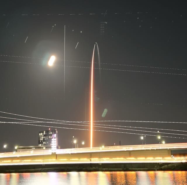 SpaceX Falcon rocket taking off and heading east from Cape Canaveral with Interstate 4 in the foreground