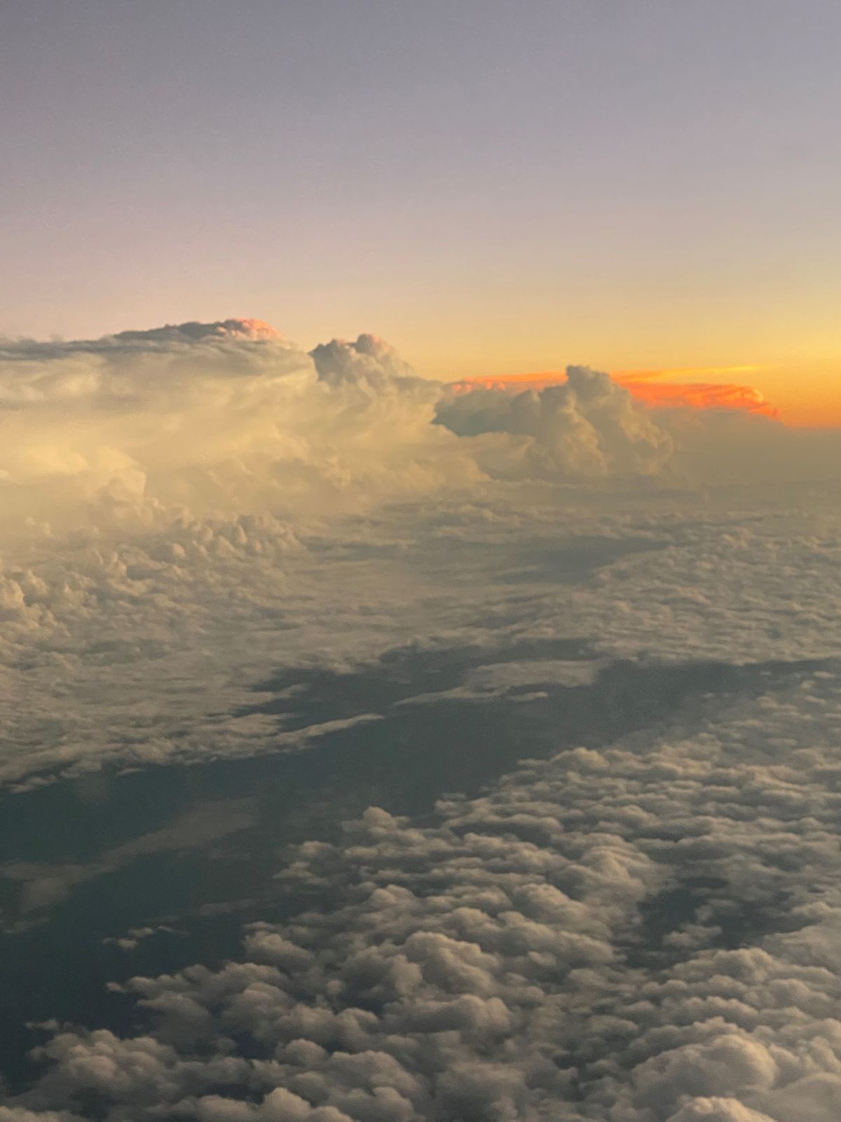 Clouds in front of a sunset taken from a plane window