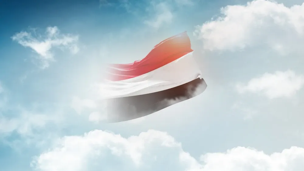 The flag of Yemen appears to dissolve in the clouds.  Shutterstock