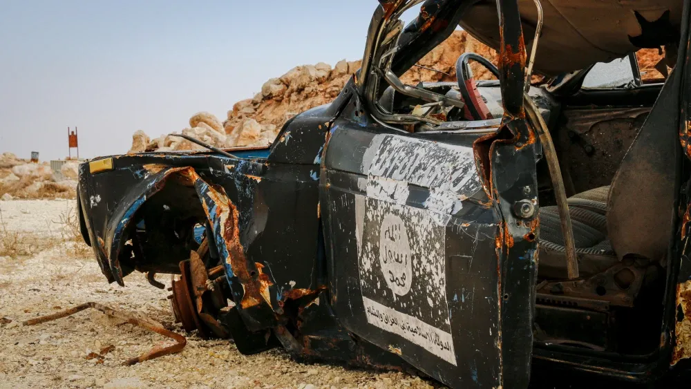 A burned-out military vehicle in the desert. Shutterstock