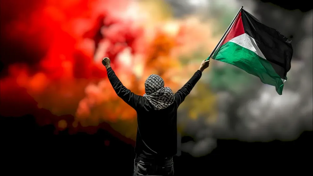 A Palestinian lifts a fist and holds high the flag of Palestine.  Shutterstock