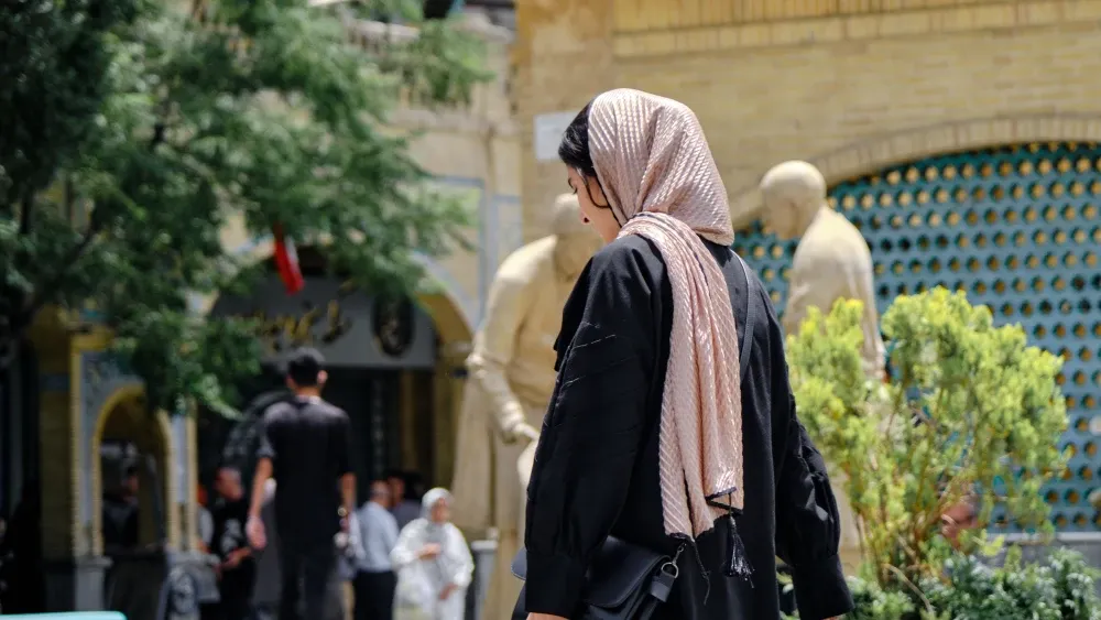 Iranians walk through street.